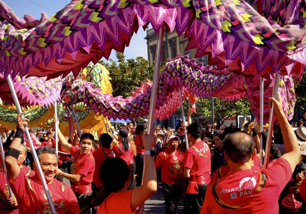 Participants holding vibrant dragon costume overhead