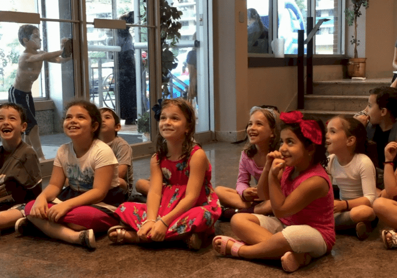 Children sitting and smiling indoors